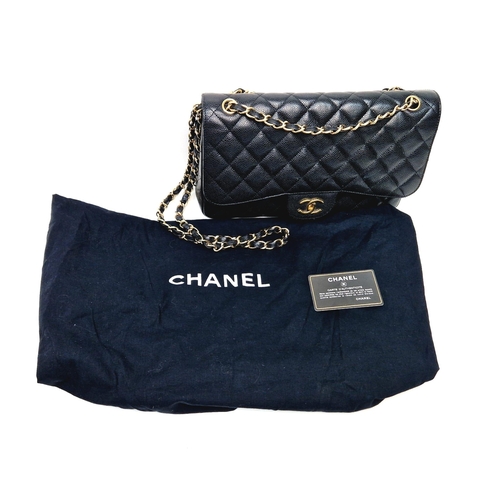 14 - A Classic Chanel Jumbo Flap Bag. Quilted caviar black calfskin. Double flaps. Interior zipped pocket... 