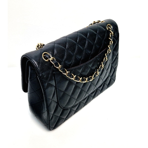 14 - A Classic Chanel Jumbo Flap Bag. Quilted caviar black calfskin. Double flaps. Interior zipped pocket... 