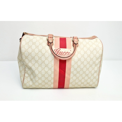 233 - A Gucci Boston Bag. Monogram canvas in a light beige hue. Pink leather trim and handles. Gilded hard... 