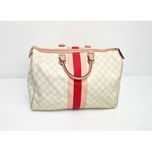 233 - A Gucci Boston Bag. Monogram canvas in a light beige hue. Pink leather trim and handles. Gilded hard... 