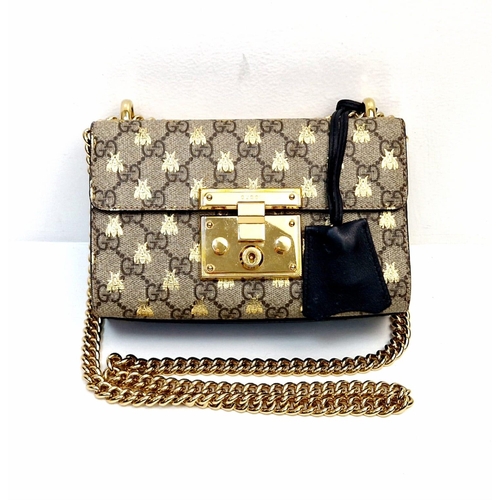 41 - A Gucci Padlock Monogram Canvas Bees' Crossbody Bag. Gilded furniture and gilded bee decoration thro... 