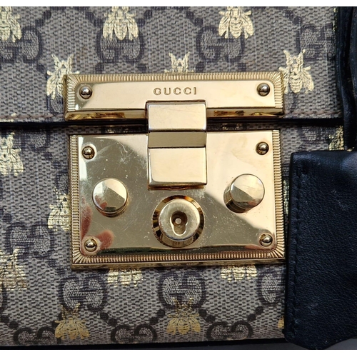 41 - A Gucci Padlock Monogram Canvas Bees' Crossbody Bag. Gilded furniture and gilded bee decoration thro... 