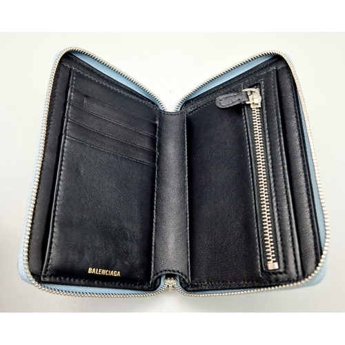 445 - A Balenciaga Blue Leather Wallet. Black leather exterior. Dust cover. In good condition but please s... 