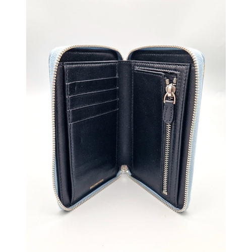 445 - A Balenciaga Blue Leather Wallet. Black leather exterior. Dust cover. In good condition but please s... 