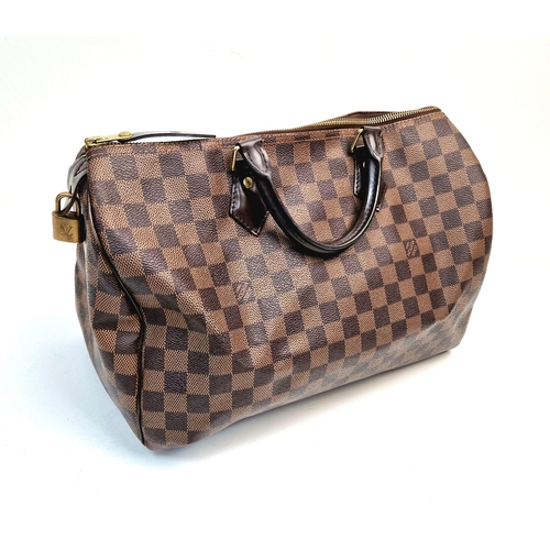 534 - A Louis Vuitton Speedy Bag. Monogram brown canvas. Brown leather handles. Plush red cloth interior. ... 