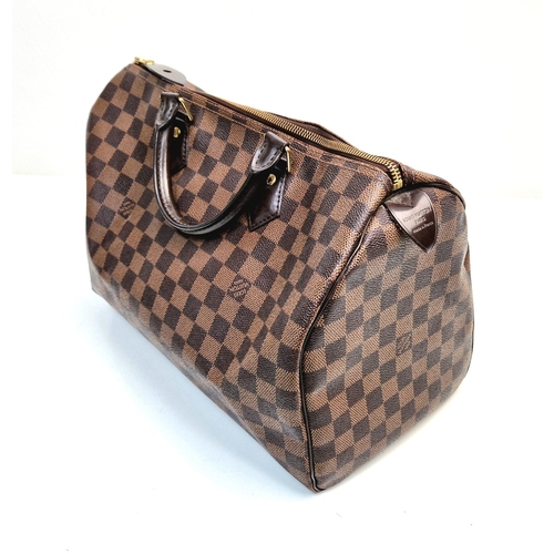 534 - A Louis Vuitton Speedy Bag. Monogram brown canvas. Brown leather handles. Plush red cloth interior. ... 