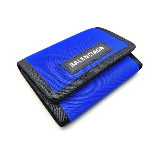 649 - A Balenciaga Blue and Black Cloth Wallet with Dust Cover. 13 x 9cm. In good condition but please see... 