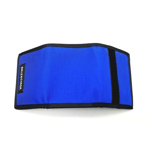 649 - A Balenciaga Blue and Black Cloth Wallet with Dust Cover. 13 x 9cm. In good condition but please see... 