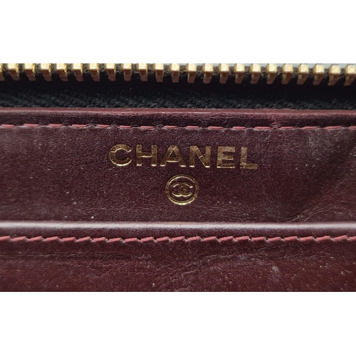 873 - A Chanel Clutch Bag/Wallet. Soft quilted black leather. Gilded Chanel exterior logo. Burgundy leathe... 