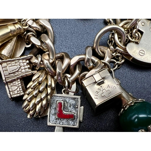 1405 - A Huge 9K Gold Charm Bracelet with Heart Clasp. 32 Eclectic pieces will intrigue the most avid charm... 