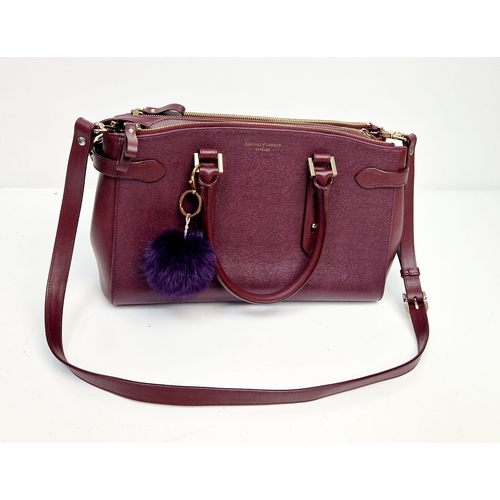 117 - An Aspinal of London Burgundy Leather Hand/Shoulder Bag. Gold-tone hardware. Three zipped openings l... 