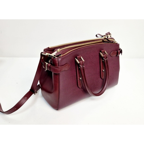 117 - An Aspinal of London Burgundy Leather Hand/Shoulder Bag. Gold-tone hardware. Three zipped openings l... 