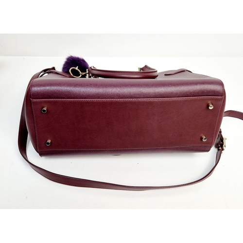 117 - An Aspinal of London Burgundy Leather Hand/Shoulder Bag. Gold-tone hardware. Three zipped openings l... 