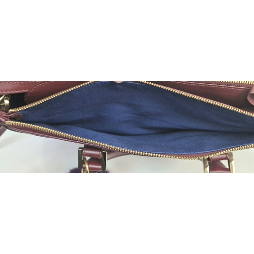 117 - An Aspinal of London Burgundy Leather Hand/Shoulder Bag. Gold-tone hardware. Three zipped openings l... 