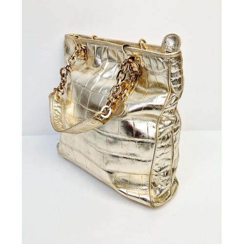 880 - A Metallic Faux Leather Versace Tote Bag. Gold-tone hardware. Dual handles. Spacious interior with z... 