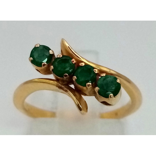 557 - 18K YELLOW GOLD GREEN STONE TWIST RING. TOTAL WEIGHT 2.7G.  SIZE I