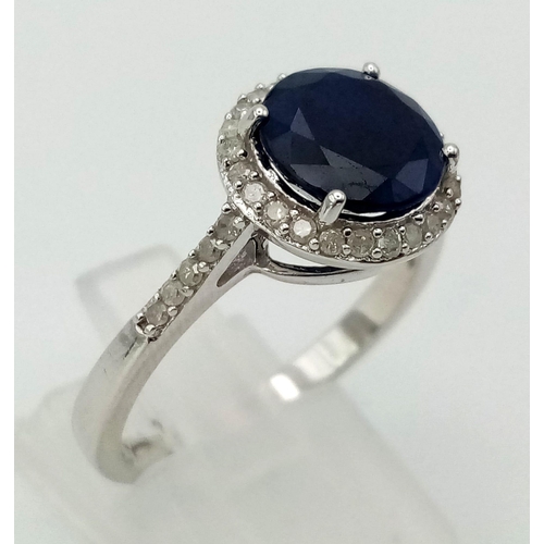 603 - A New Sterling Silver Sapphire and Diamond Ring Size R. Set with a 9mm Round Cut Sapphire Centre Sto... 