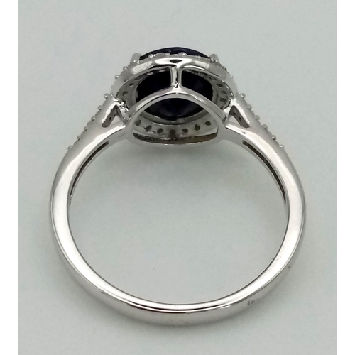 603 - A New Sterling Silver Sapphire and Diamond Ring Size R. Set with a 9mm Round Cut Sapphire Centre Sto... 