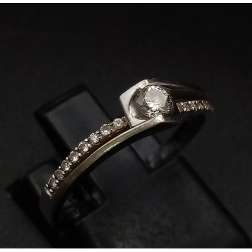 717 - 18K WHITE GOLD DIAMOND SOLITAIRE TWIST RING.  0.20CT DIAMOND. TOTAL WEIGHT  2.2G.  SIZE M