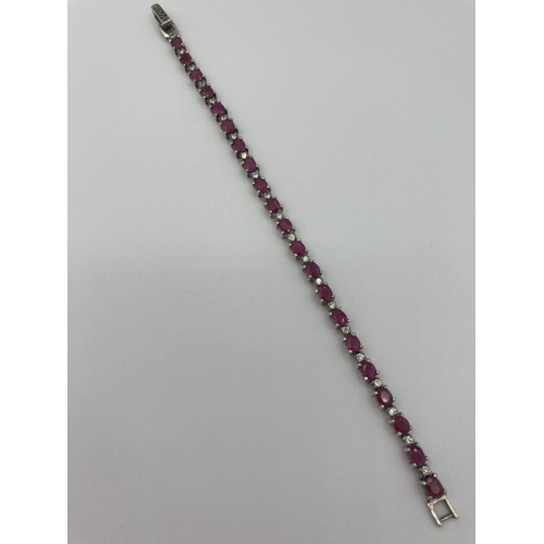 173 - SILVER and RUBY TENNIS BRACELET,having 21 oval cushion cut rubies with sparkling clear gemstone spac... 