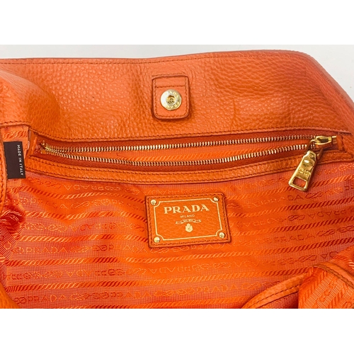 1456 - A Prada Burnt Orange Tote Bag. Soft leather with gilded hardware. Inner zipped and flap compartments... 