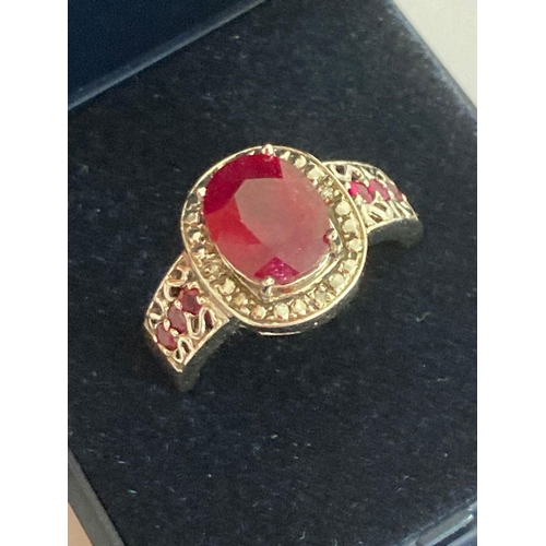 300 - SILVER and RUBY RING ,Having large oval cut  RUBY SOLITAIRE set to top with DIAMOND  surround, addit... 