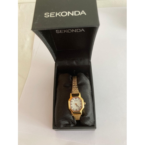 594 - Ladies SEKONDA WRISTWATCH in Gold Tone. Having Octagonal white face with expandable bracelet. Quartz... 