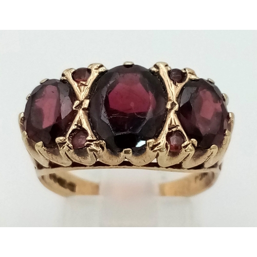 949 - A Vintage 9K Yellow Gold Garnet Three Stone Ring. Three quality, rich garnets. Size O. 4.36g total w... 