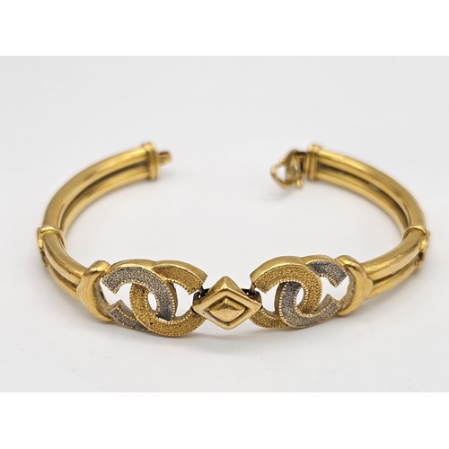 371 - A 22k yellow gold lot consisting of a bangle with Two CC ornaments and a chain necklace with a heart... 