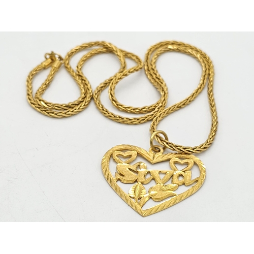 371 - A 22k yellow gold lot consisting of a bangle with Two CC ornaments and a chain necklace with a heart... 