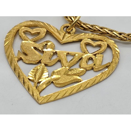 371 - A 22k yellow gold lot consisting of a bangle with Two CC ornaments and a chain necklace with a heart... 