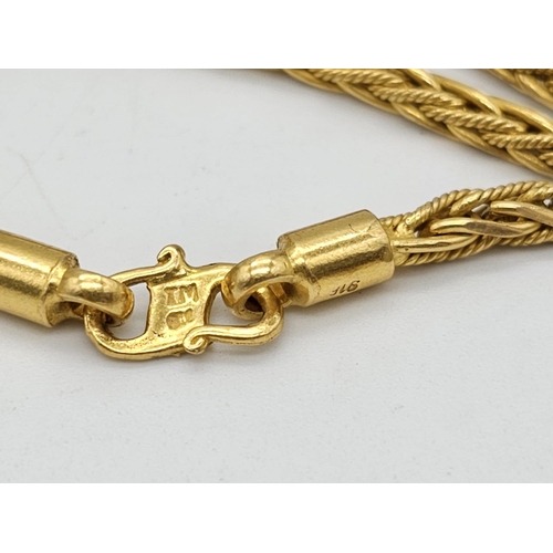 371 - A 22k yellow gold lot consisting of a bangle with Two CC ornaments and a chain necklace with a heart... 