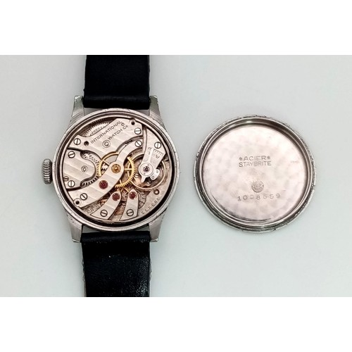 245 - An IWC watch. 30 mm case, white metal bezel, white dial with Arabic numerals. Antimagnetic manual mo... 