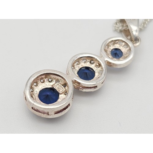 1459 - A SIMPLY SILVER NECKLACE AND PENDANT WITH 3 GRADUATED BLUE STONES SET IN SILVER AND SURROUNDED BY ZI... 