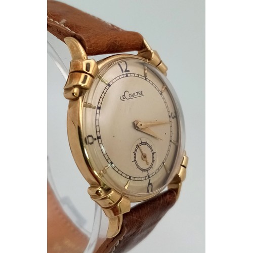 449 - An 18m k yellow Le Coultre watch.  28 mm case, cream coloured dial with gold hour marks and hands, s... 