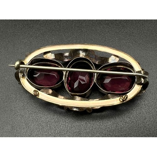 1431 - Early Victorian 3 stone amethyst Brooch in a fancy wavy swirl frame. Set in 9K gold. 11.2g total wei... 