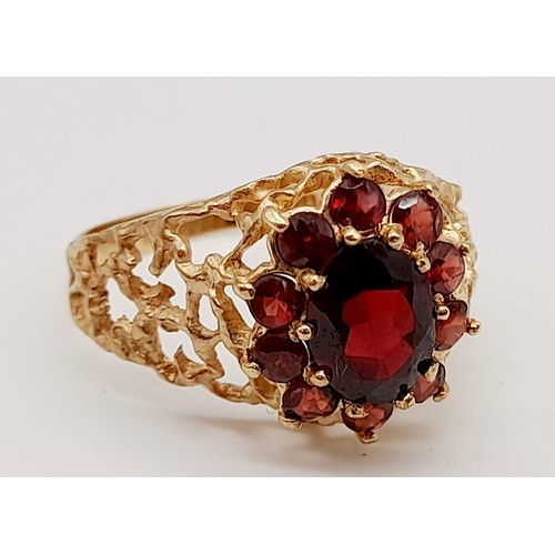 1438 - 1960’s oval cluster garnet ring surrounded by a halo of bright red garnets in a stylish bark design.... 