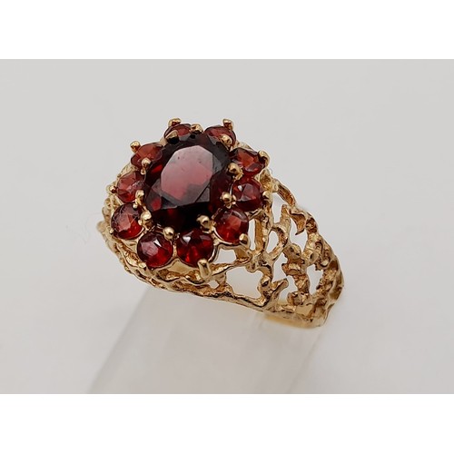 1438 - 1960’s oval cluster garnet ring surrounded by a halo of bright red garnets in a stylish bark design.... 