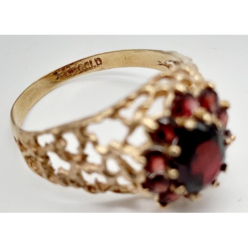 1438 - 1960’s oval cluster garnet ring surrounded by a halo of bright red garnets in a stylish bark design.... 