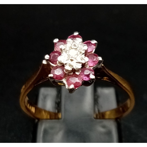 55 - An 18K Yellow Gold Ruby and Diamond Ring. Central small diamond with a ruby gemstone halo. Size M 1/... 