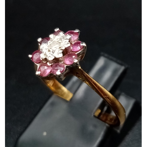 55 - An 18K Yellow Gold Ruby and Diamond Ring. Central small diamond with a ruby gemstone halo. Size M 1/... 