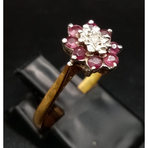 55 - An 18K Yellow Gold Ruby and Diamond Ring. Central small diamond with a ruby gemstone halo. Size M 1/... 