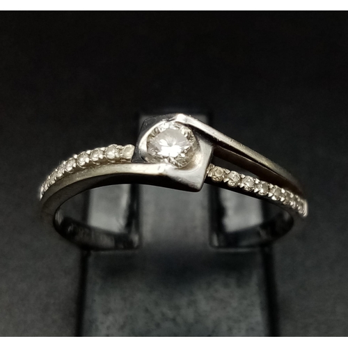 751 - 18K WHITE GOLD DIAMOND SOLITAIRE TWIST RING.  0.20CT DIAMOND. TOTAL WEIGHT  2.2G.  SIZE M