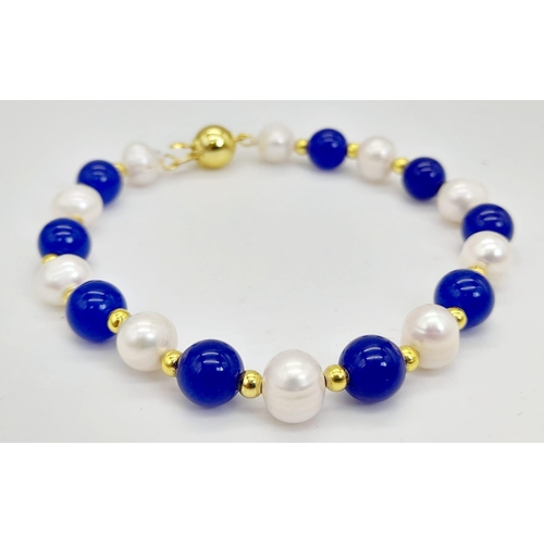 1109 - A Lapis Lazuli and Cultured Pearl Bracelet. Gilded spacers and clasp.