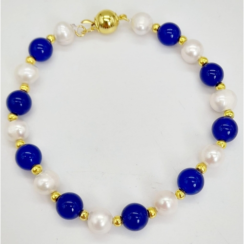 1109 - A Lapis Lazuli and Cultured Pearl Bracelet. Gilded spacers and clasp.