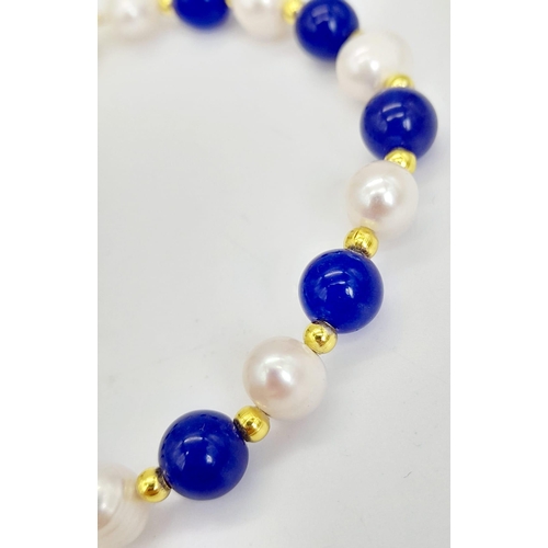 1109 - A Lapis Lazuli and Cultured Pearl Bracelet. Gilded spacers and clasp.