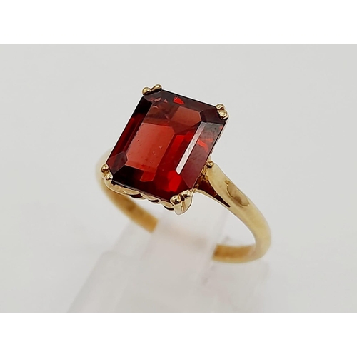 488 - A 9K Yellow Gold Garnet Solitaire Ring. A deep red rectangular garnet. Size M. 2.8g total weight.