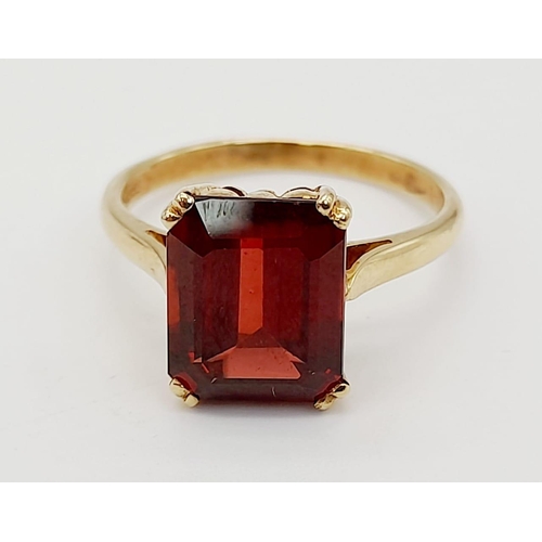 488 - A 9K Yellow Gold Garnet Solitaire Ring. A deep red rectangular garnet. Size M. 2.8g total weight.