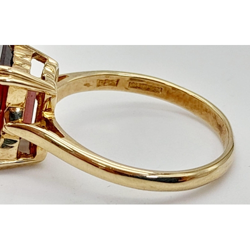 488 - A 9K Yellow Gold Garnet Solitaire Ring. A deep red rectangular garnet. Size M. 2.8g total weight.