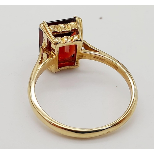 488 - A 9K Yellow Gold Garnet Solitaire Ring. A deep red rectangular garnet. Size M. 2.8g total weight.